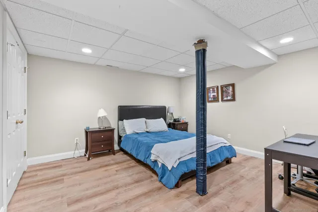 a bedroom with a bed and wooden floor