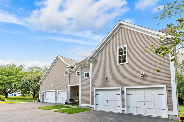 a view of house that has a yard and garage