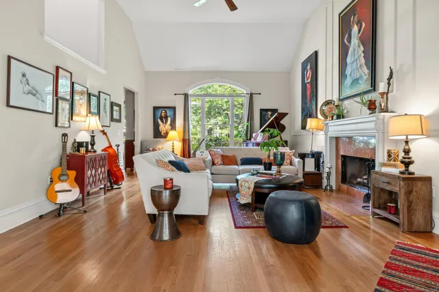 a living room with furniture a fireplace and a large window