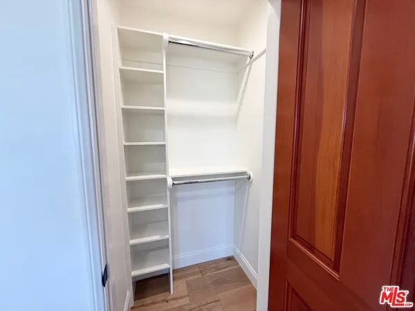 a view of walk in closet with empty racks