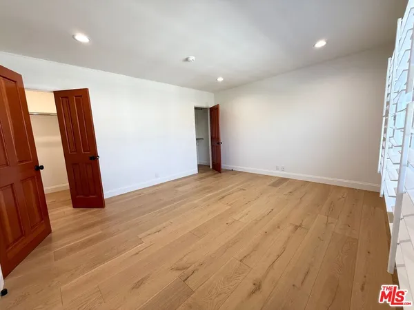 an empty room with wooden floor and a window