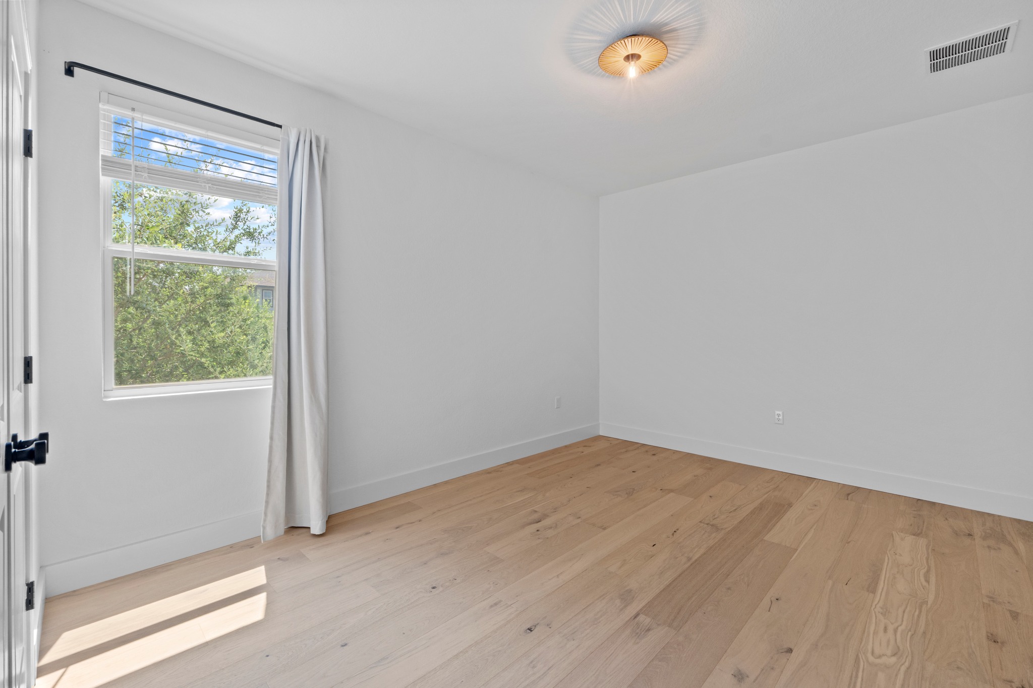 1101 Skeeter Cove Austin, TX 78748 - Photo 25 of 31 Natural light streams into this serene bedroom, highlighting the smooth wood flooring.