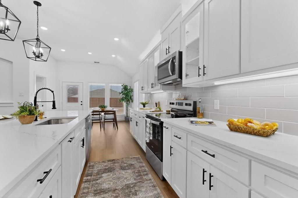 101 Boone Street Edgewood, TX 75117 - Photo 14 of 40 a kitchen with white cabinets appliances and a center island