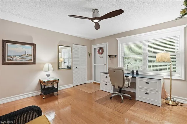 a view of a livingroom with workspace and a window