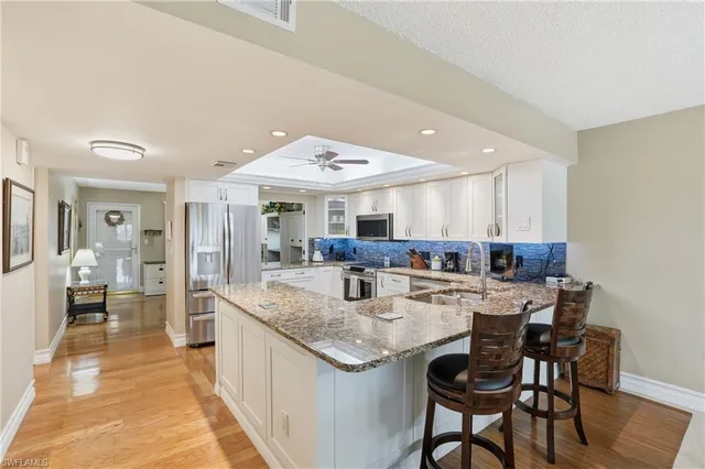 a kitchen with stainless steel appliances granite countertop dining room and chairs