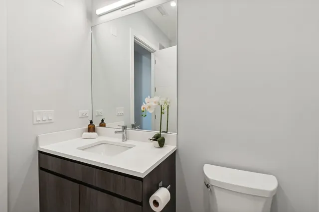 a bathroom with a sink toilet and mirror