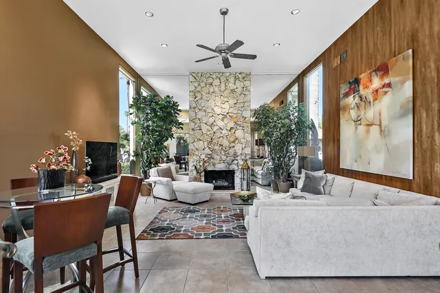 a living room with furniture a fireplace and a chandelier
