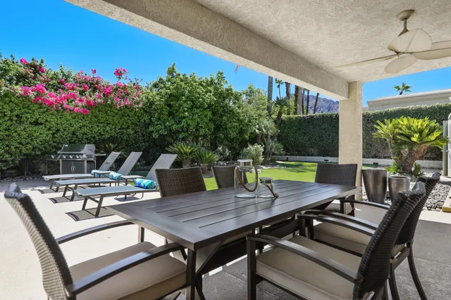 a view of a dinning table and chairs in patio of the house