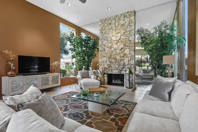 a living room with furniture a flat screen tv and a fireplace