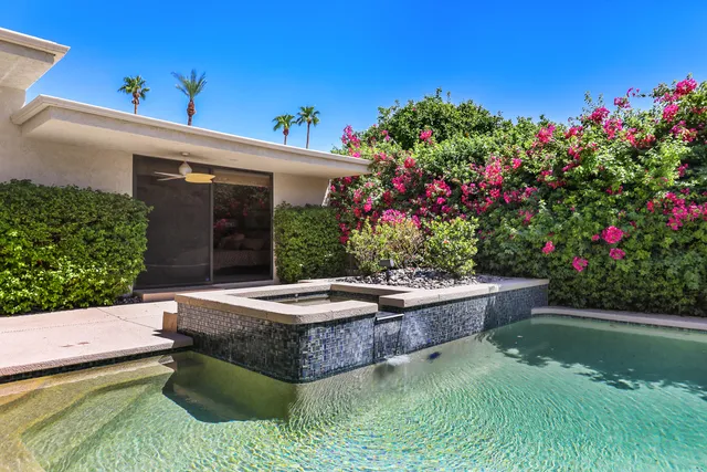 a backyard of a house with fountain table and chairs