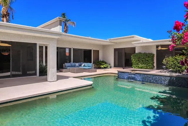 a view of a house with swimming pool patio and a garden