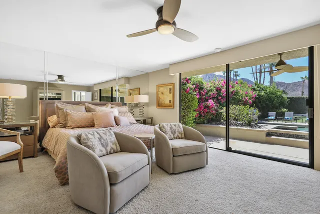a living room with furniture potted plant and a large window