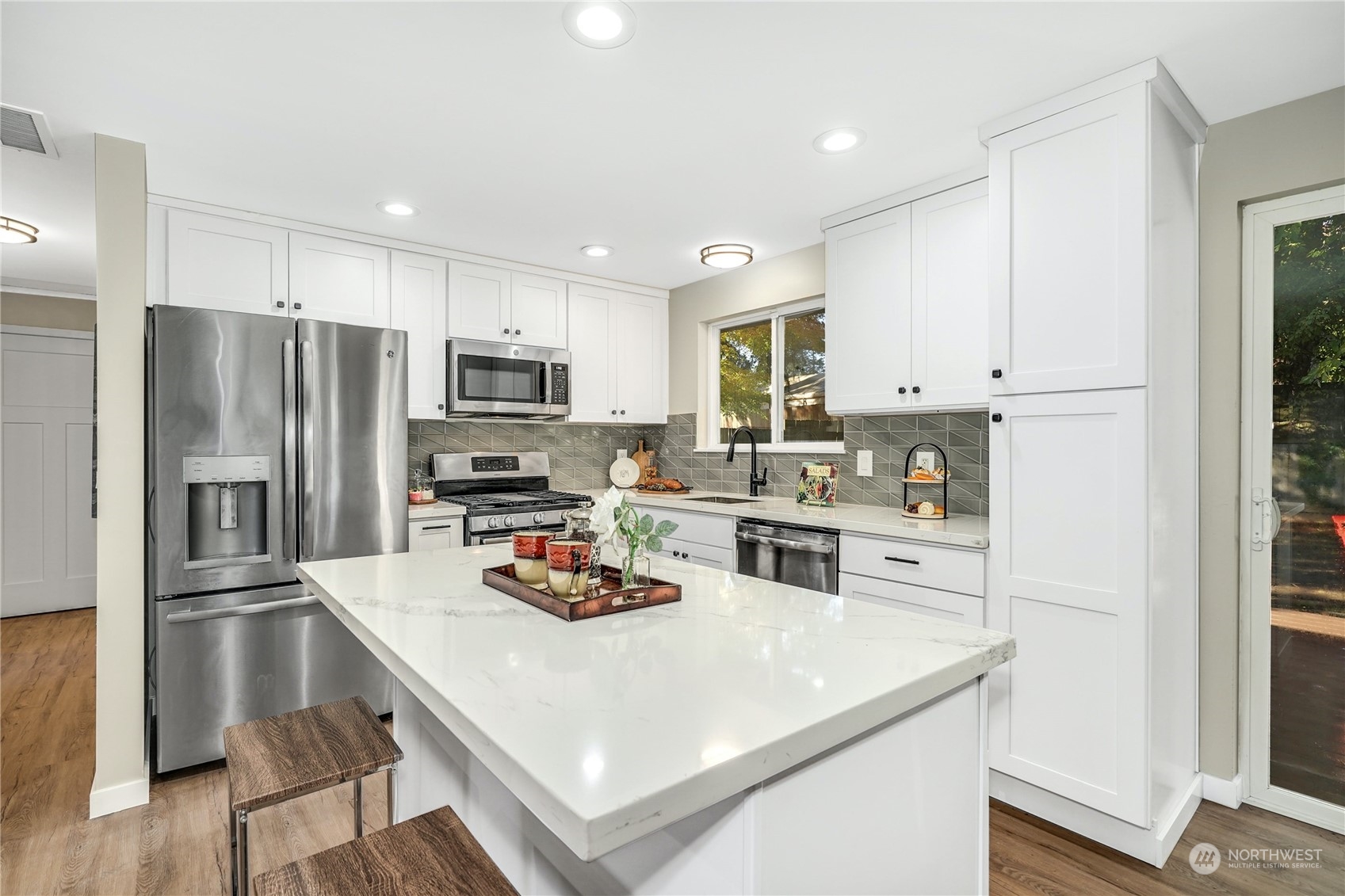 1821 Whitman Avenue Northeast Renton, WA 98059 - Photo 8 of 24 a kitchen with white cabinets and stainless steel appliances