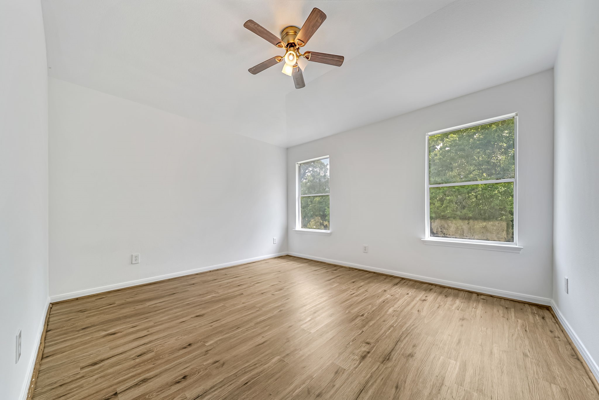23526 Whispering Maple Drive Spring, TX 77373 - Photo 22 of 26 an empty room with wooden floor ceiling fan and windows