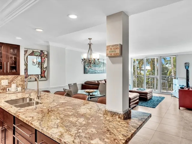 a kitchen with granite countertop kitchen island a sink and a large window