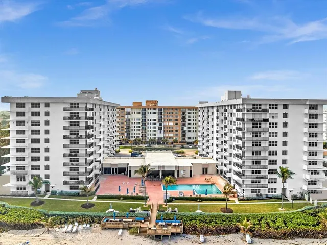 a living room with furniture floor to ceiling window and pool table