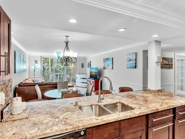 a kitchen with stainless steel appliances kitchen island granite countertop a refrigerator and a stove top oven