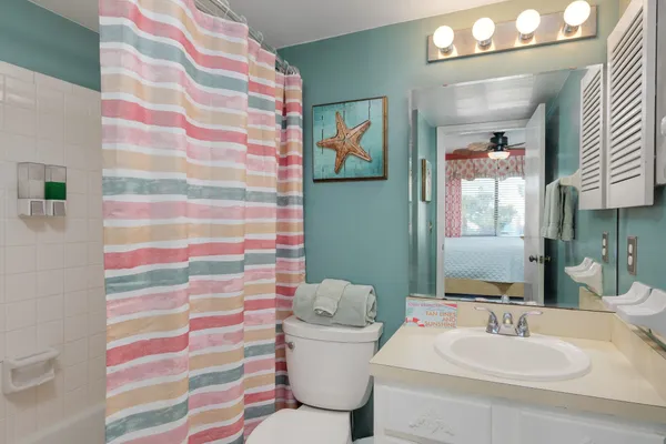 a bathroom with a sink and mirror with toilet