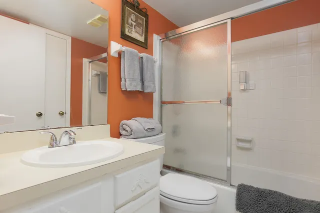 a bathroom with a granite countertop sink toilet and shower