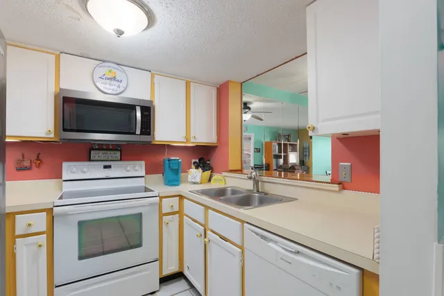 a kitchen with a sink stove and microwave
