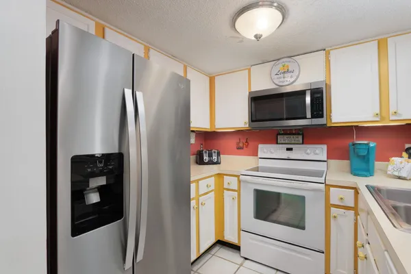 a kitchen with a refrigerator and a stove top oven