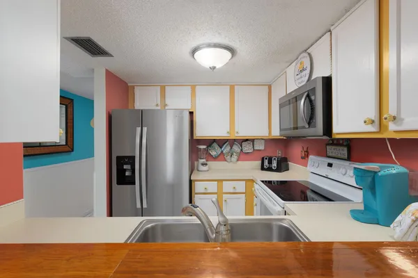 a kitchen with a sink a refrigerator and a stove top oven