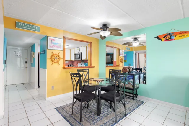 a view of a dining room with furniture and a chandelier fan