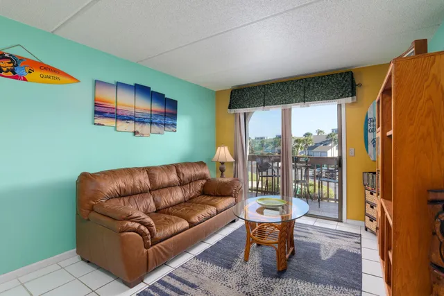 a living room with furniture a flat screen tv and a floor to ceiling window