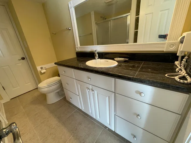 a bathroom with a sink a toilet a mirror and shower