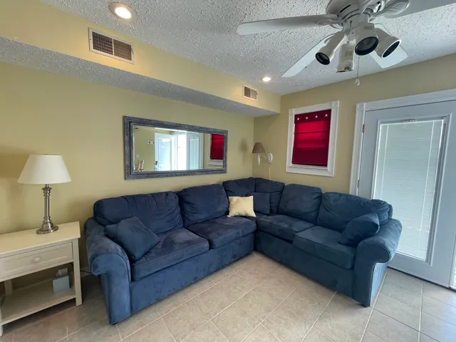 a living room with furniture and a ceiling fan