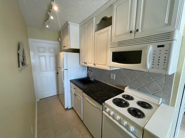 a kitchen with stainless steel appliances granite countertop a stove and a refrigerator