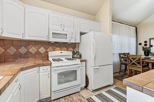 a kitchen with a white cabinets and window
