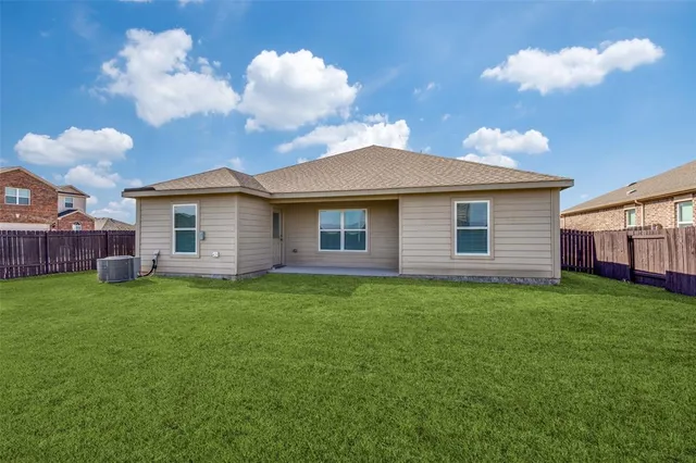 a view of a yard in front of a house with a large tree