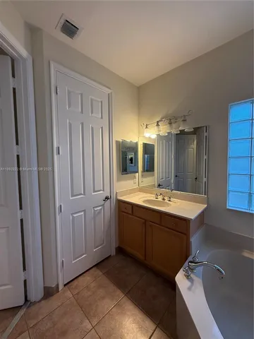 a bathroom with a tub sink shower and mirror