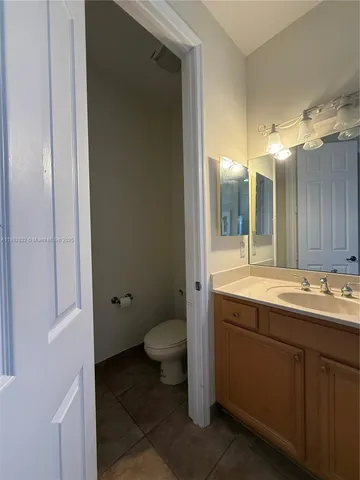 a bathroom with a sink and mirror with toilet