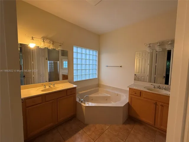a bathroom with a tub sink shower and mirror