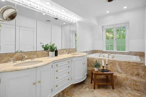 a bath room with a sink and a large mirror