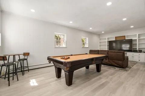 a room with furniture pool table and flat screen tv