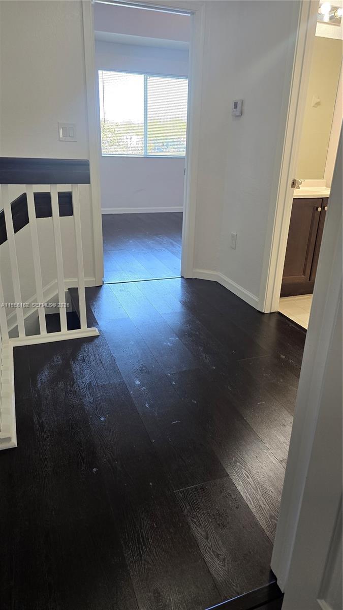 2755 Southeast 15th Road, Unit 101 Homestead, FL 33035 - Photo 14 of 18 an empty room with wooden floor and windows
