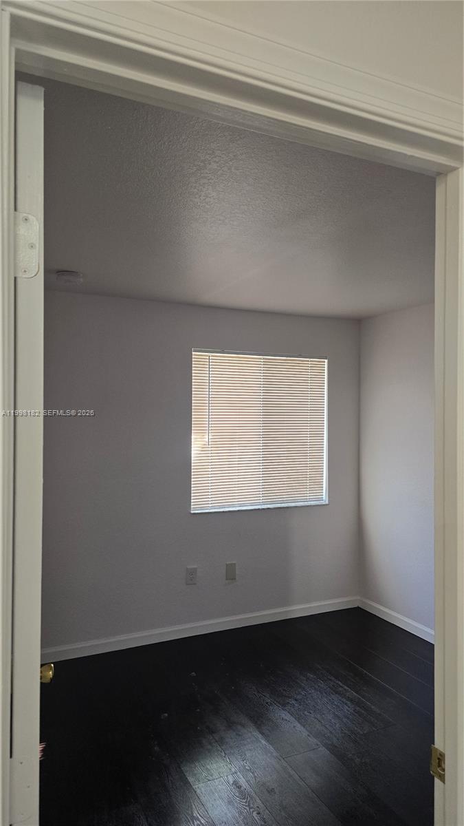 2755 Southeast 15th Road, Unit 101 Homestead, FL 33035 - Photo 16 of 18 an empty room with wooden floor and windows