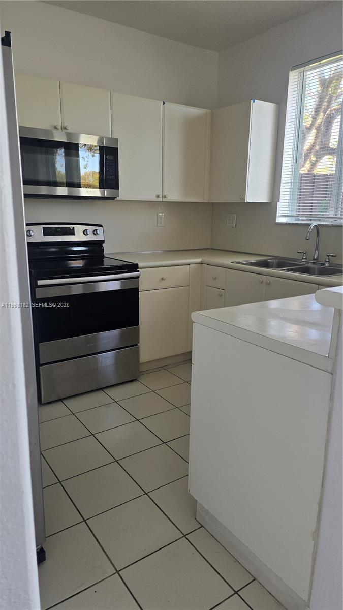 2755 Southeast 15th Road, Unit 101 Homestead, FL 33035 - Photo 8 of 18 a kitchen with appliances a sink and a stove