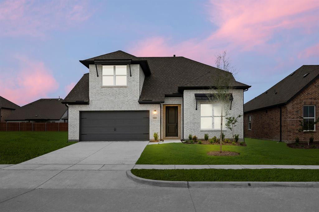 a front view of a house with a yard and garage