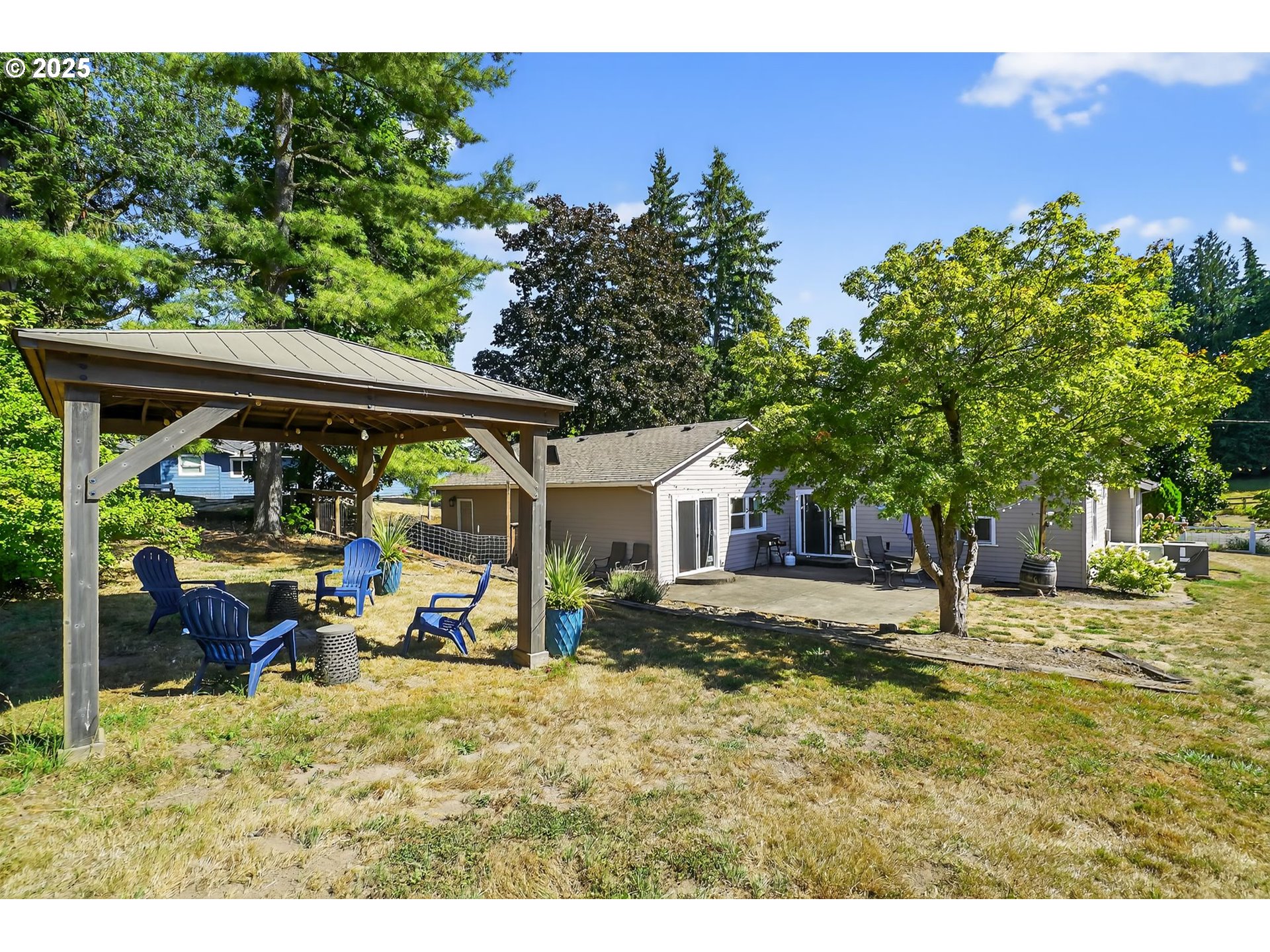 8487 South Sconce Road Canby, OR 97013 - Photo 24 of 27 a backyard of a house with table and chairs