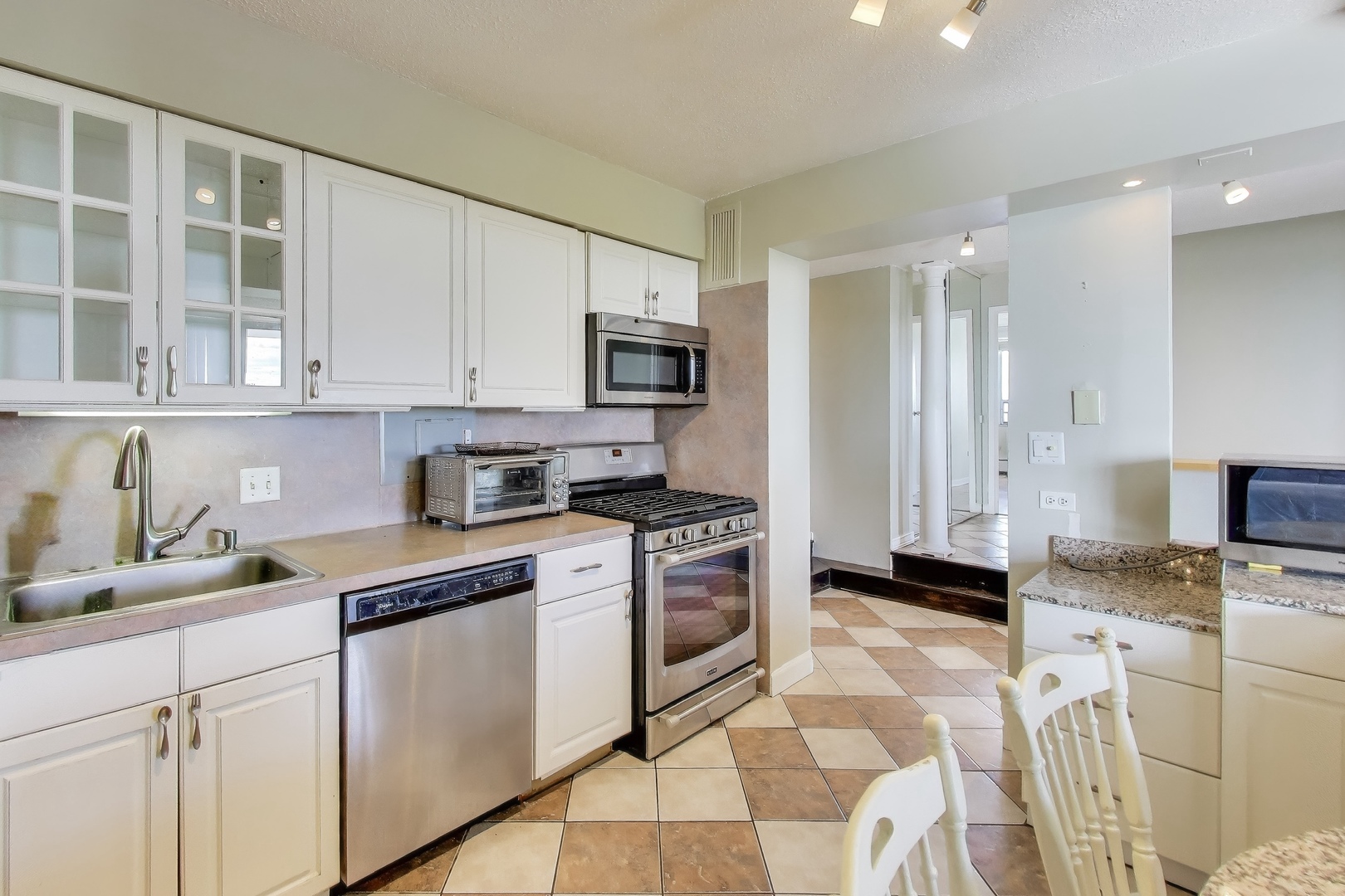 8809 West Golf Road, Unit 8I Niles, IL 60714 - Photo 6 of 27 a kitchen with stainless steel appliances granite countertop a stove a sink and a refrigerator