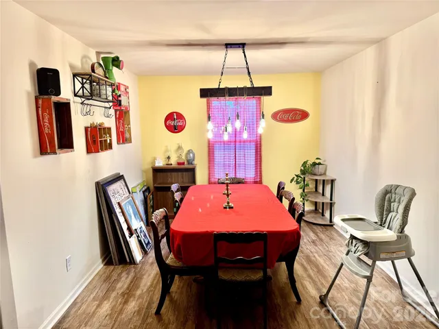 a backyard of a house with table and chairs and potted plants