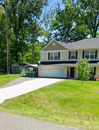 a front view of a house with yard and green space