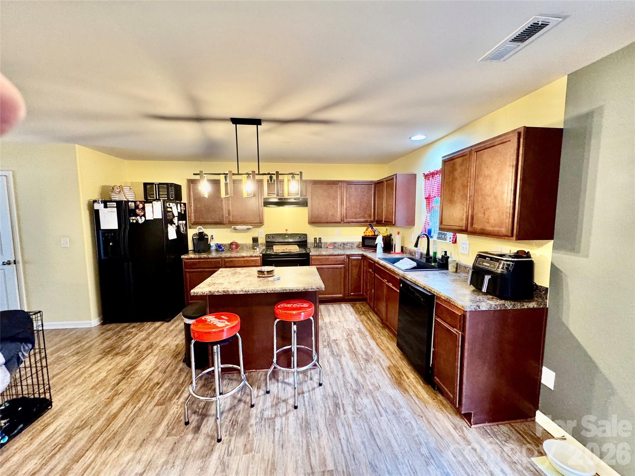 658 Buckskin Road Oakboro, NC 28129 - Photo 21 of 30 a kitchen with stainless steel appliances granite countertop a refrigerator a stove top oven a sink dishwasher and dining table with wooden floor