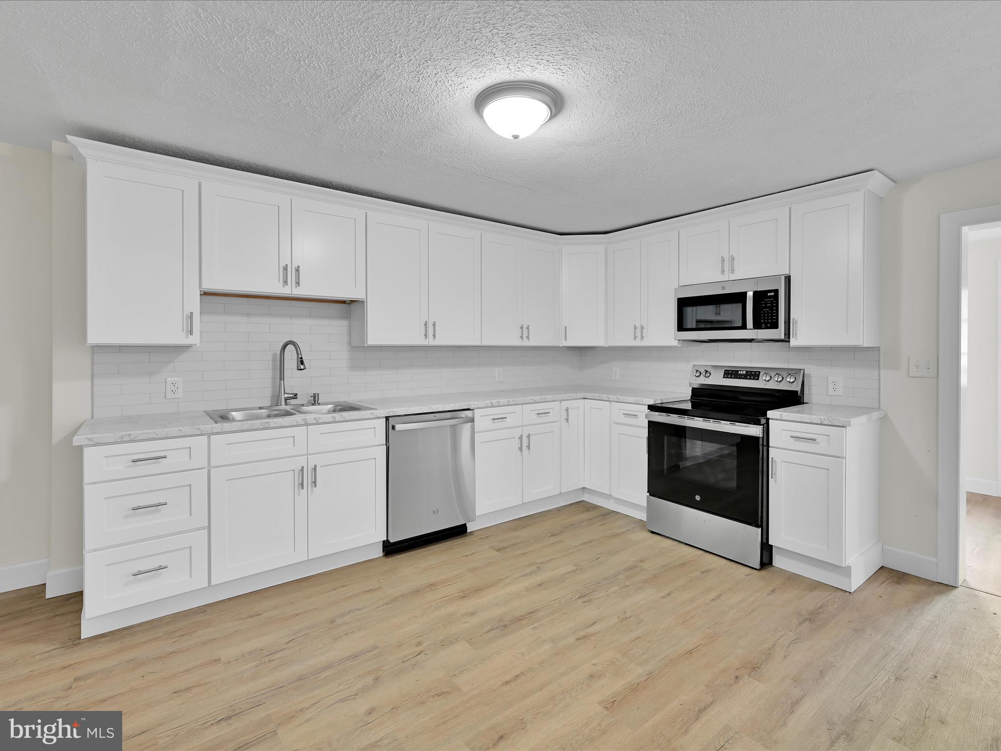 142 West Ruddle Street Coaldale, PA 18218 - Photo 7 of 28 a kitchen with granite countertop white cabinets and stainless steel appliances