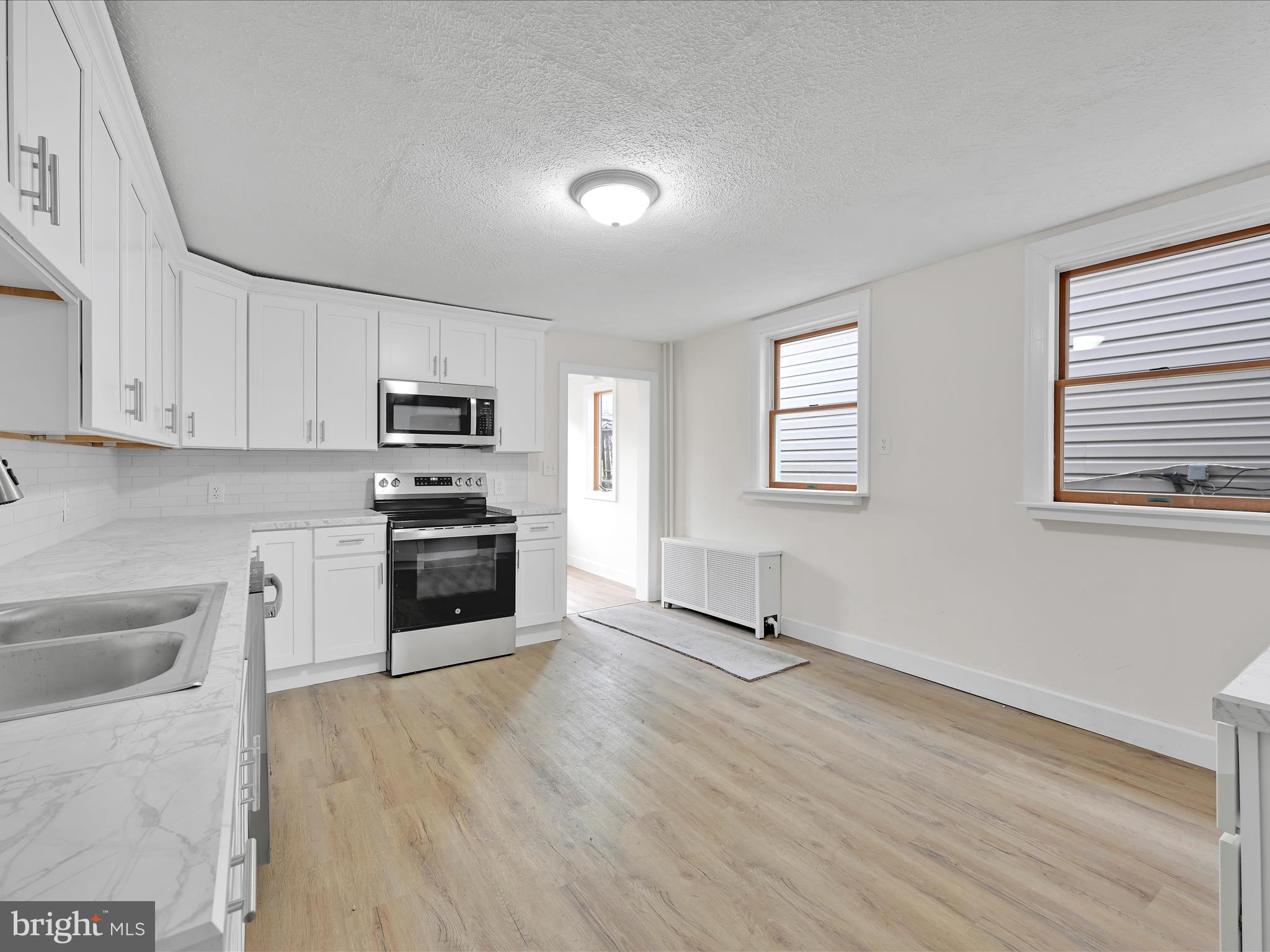 142 West Ruddle Street Coaldale, PA 18218 - Photo 8 of 28 a kitchen with granite countertop a stove a sink and a microwave