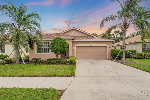 a front view of a house with a garden and trees